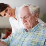 A woman carer concerned about an elderly man looking depressed