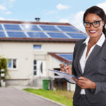 Businesswoman Filling Document In Front Of House